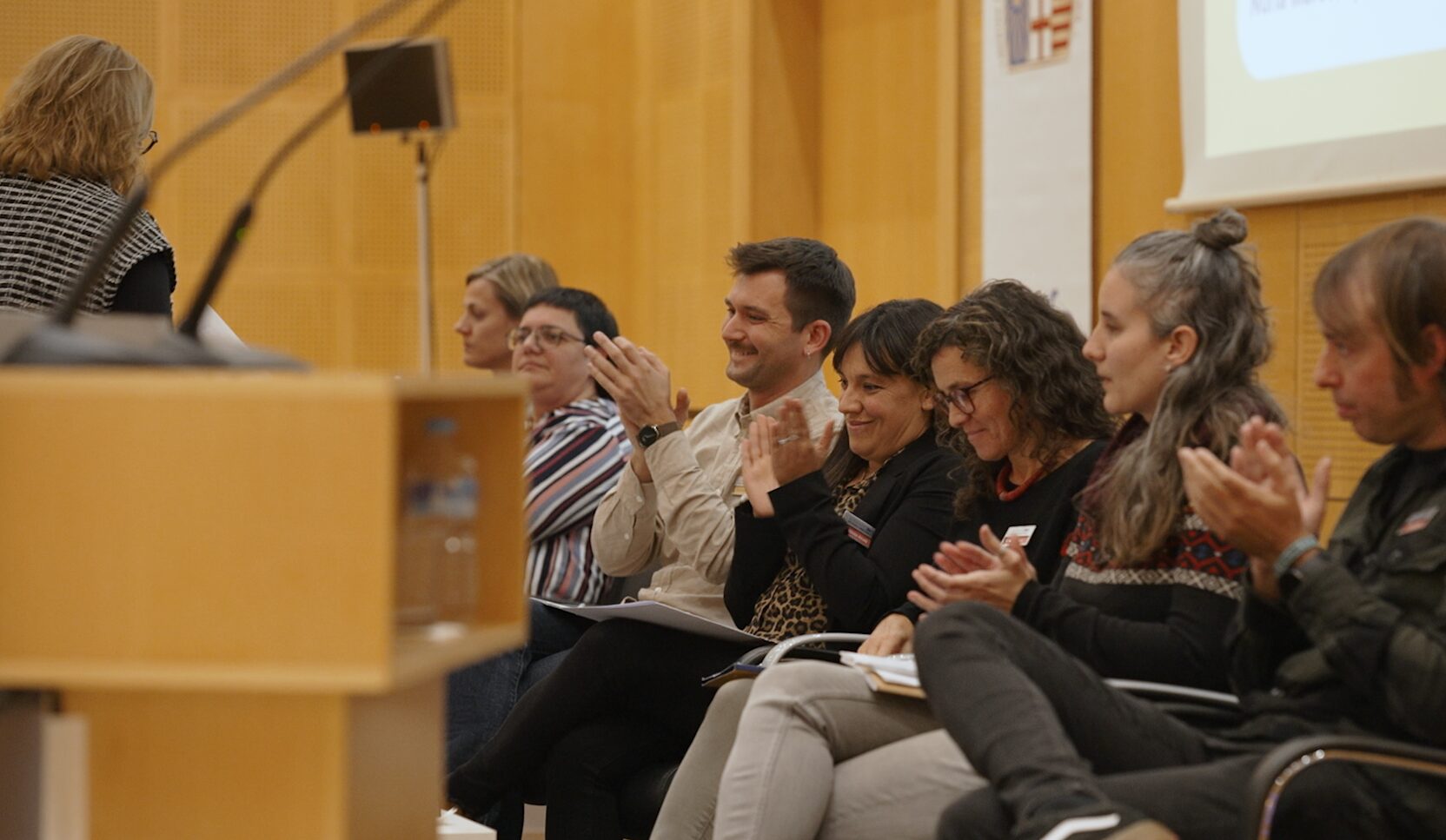 Persones aplaudint en una trobada sobre Cap a una educació a temps complet a Catalunya